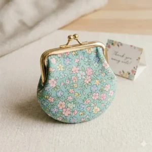 A stylish floral print coin purse purse with a gold clasp fastener.