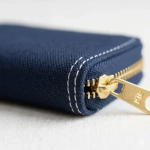 Close-up detail of the durable stitching and zipper on a navy canvas small zip coin purse.