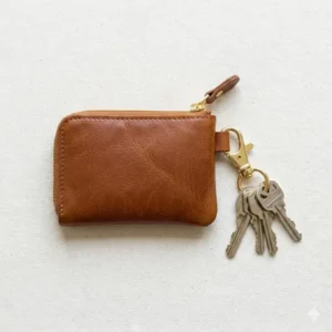 Illustration of a small zip coin pouch attached to a set of keys using a sturdy metal lobster clasp for travel convenience.