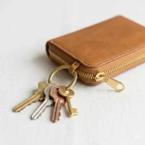 Functional small zip coin purse featuring an attached metal keyring for securing house keys.