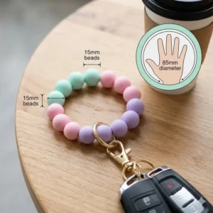 A colorful illustration of a flexible silicone beaded wrist keychain strap with a heavy-duty gold clasp.